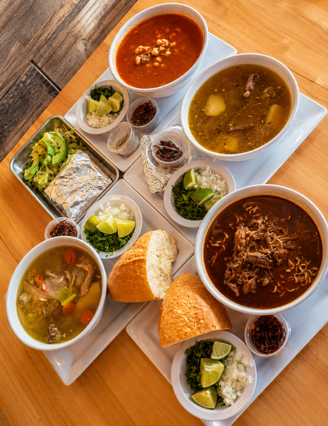 Assorted Mexican soups including birria ramen, pozole and caldo de pollo with bread